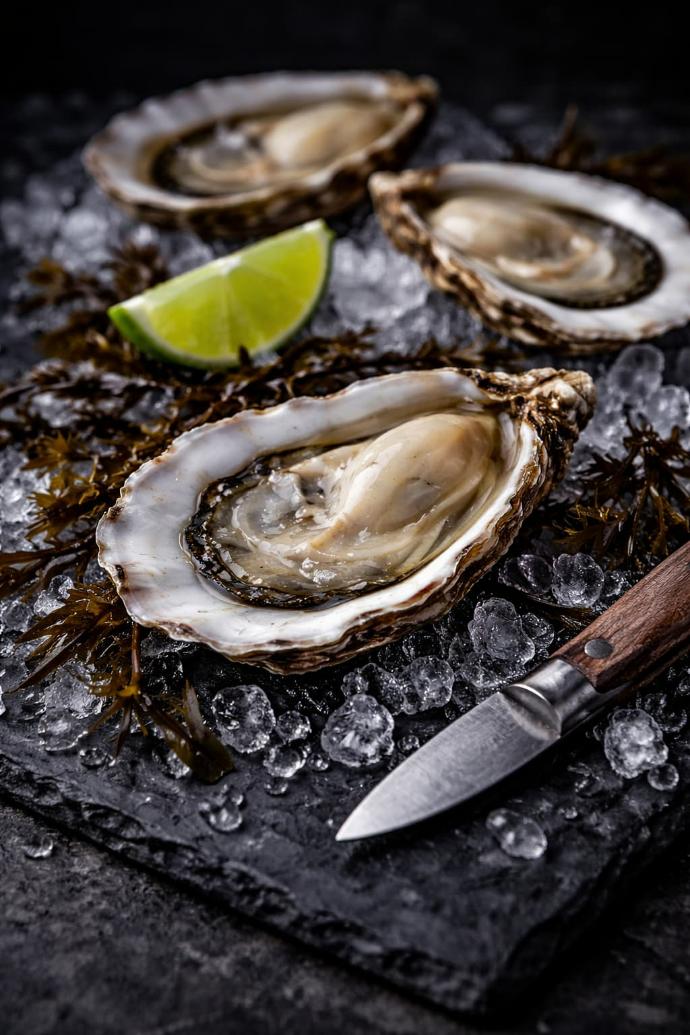 Huître premium sur glace, style gastronomique sombre.
